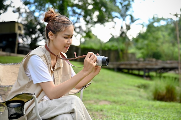 Hipster jeune femme asiatique prenant une photo de la belle forêt avec son appareil photo argentique rétro