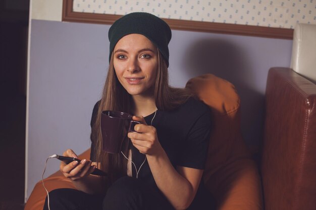 Hipster jeune femme mignonne écoutant de la musique dans les écouteurs