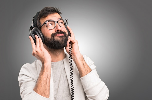 Hipster man écoute de la musique sur fond gris