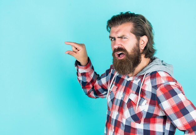 Hipster masculin avec des cheveux soignés à la mode et une barbe pointant du doigt