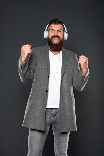 Hipster porter des écouteurs de gadget de technologie moderne Excellent son Concept de bibliothèque musicale Marcher avec de la musique Mode de vie citoyen urbain Musique toujours avec moi Homme écoutant de la musique casque sans fil