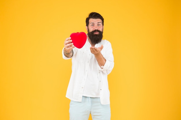 Hipster romantique partageant l'amour Répandre l'amour Amant généreux Symbole de l'amour Du cœur sincère Je t'aime Être honnête Mec romantique avec jouet coeur rouge Concept de romance Célébrez la Saint Valentin