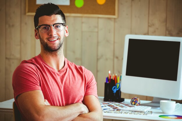 Hipster souriant assis à son bureau