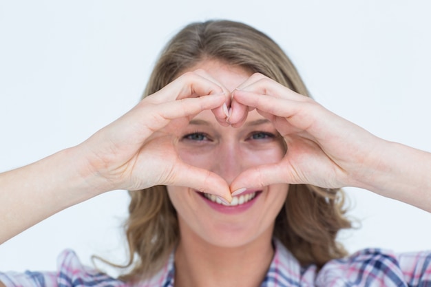 Photo hipster souriant, en forme de coeur avec ses mains