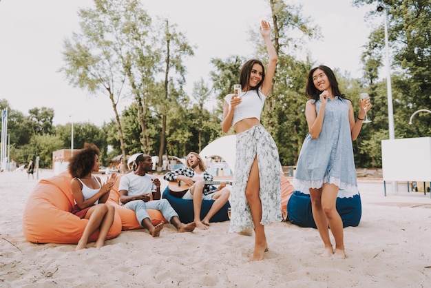 Hipsters jouant de la guitare chantant la danse sur la plage