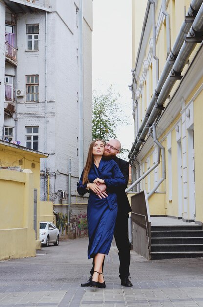 Histoire d'amour urbaine. jeune homme barbu en costume bleu. Jolie femme en robe. Couple marchant. Date