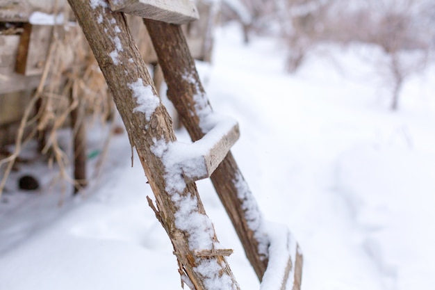 Hiver, escaliers en bois dans la rue, recouverts de neige.