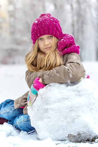 Hiver - petite fille souriante à l'extérieur au moment des chutes de neige