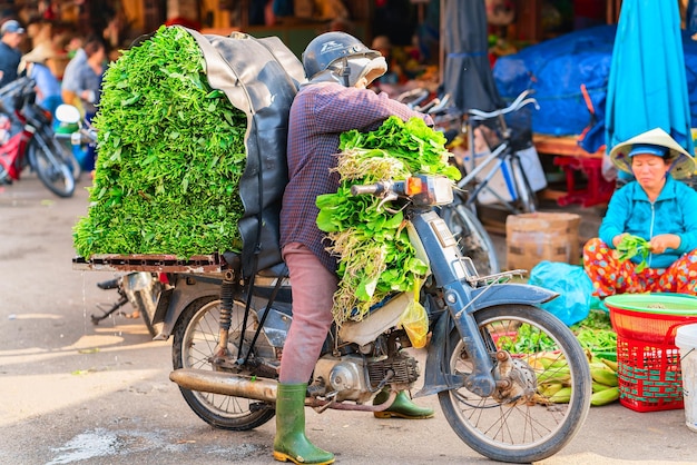 Hoi An, Vietnam - 17 février 2016 : Vendeur vendant des légumes verts de la moto sur le marché de rue dans la vieille ville de Hoi An, Vietnam