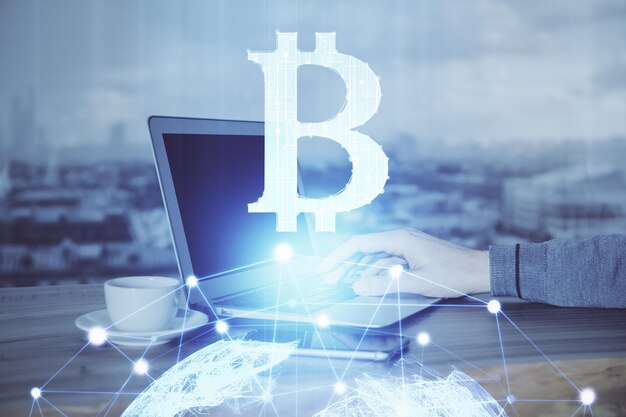 Hologramme de thème de devise crypto avec homme d'affaires travaillant sur ordinateur sur fond Concept de blockchain Double exposition
