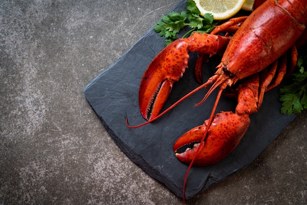 homard aux légumes et citron sur plaque d&#39;ardoise noire