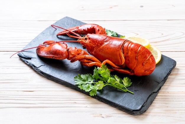 homard aux légumes et citron sur plaque d&#39;ardoise noire