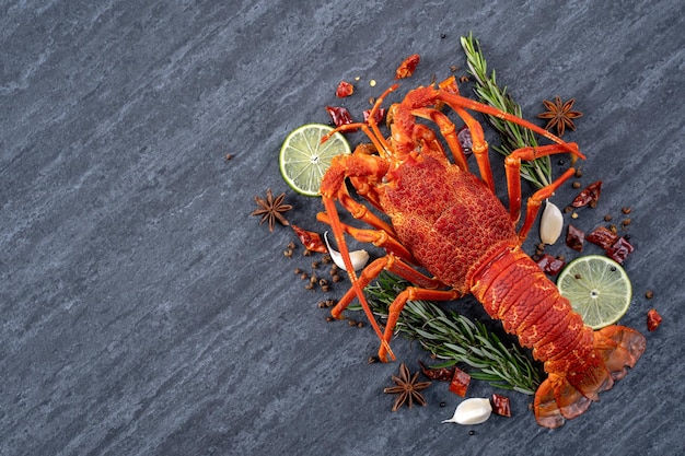 Homard bouilli cuit délicieux dîner repas de fruits de mer avec couteau et fourchette sur fond d'ardoise en pierre noire conception de menus de restaurant vue de dessus au-dessus