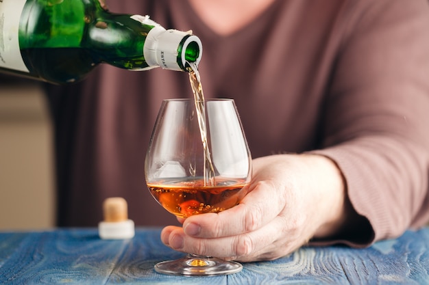 Homme abusant de l'alcool pour se détendre, whisky en verre