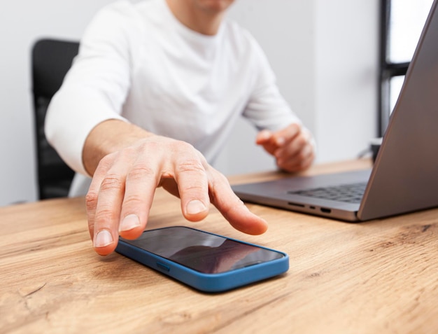 Photo l'homme accro à son téléphone tire sa main pour le prendre et jouer à des jeux ou surfer sur les médias sociaux concept de dépendance au téléphone