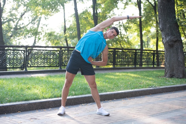 Homme actif en vêtements de sport faisant des exercices d'étirement