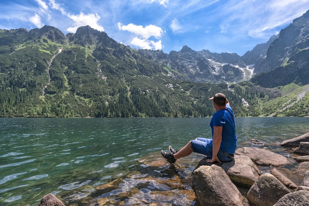 L'homme admire le paysage de montagne sur le lac