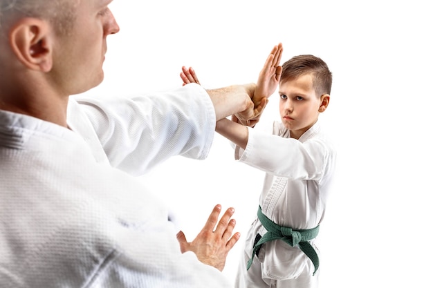 Photo homme et adolescent combattant à l'entraînement d'aikido à l'école d'arts martiaux mode de vie sain et concept sportif. combattants en kimono blanc sur mur blanc. des hommes de karaté aux visages concentrés en uniforme.