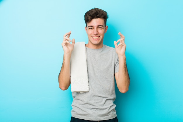 Homme adolescent jeune fitness joyeux rire beaucoup.