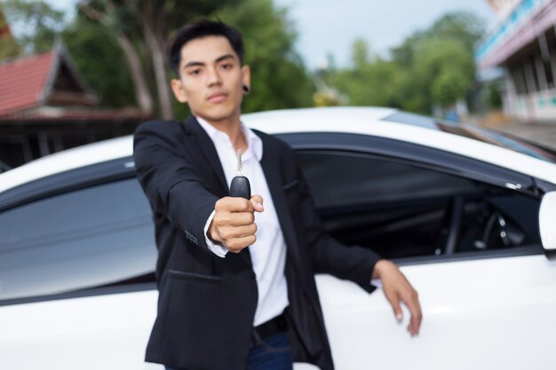 Homme adulte adulte en costume et tenant une clé de voiture à la main