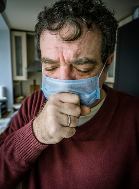 Photo homme adulte dans une masque médicale tousse