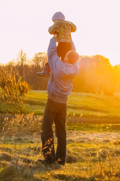 Homme adulte jouant avec un enfant à l'extérieur par une chaude journée de printemps