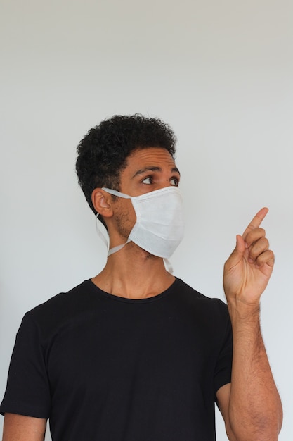 Homme adulte noir portant un masque de coronavirus isolé sur blanc