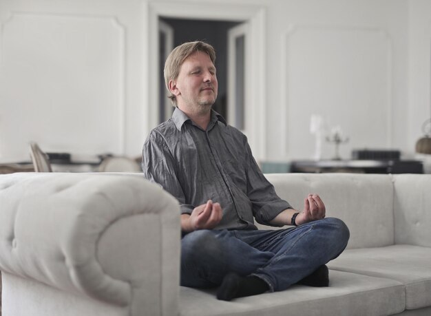 Un homme adulte pratique le yoga à la maison