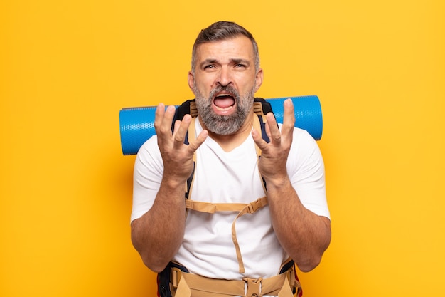 Homme adulte à la recherche désespérée et frustrée, stressée, malheureuse et agacée, criant et hurlant