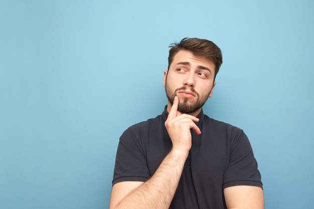 L'homme adulte réfléchi est isolé sur bleu