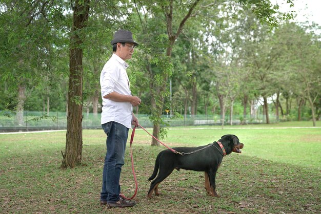 Homme adulte et son chien de compagnie dans le parc Vue latérale