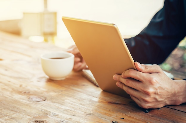 homme d&#39;affaire utilisant une tablette sur table en bois dans un café.