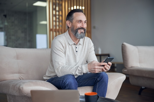 Homme d'affaires adulte est assis et se détend dans un espace de bureau confortable