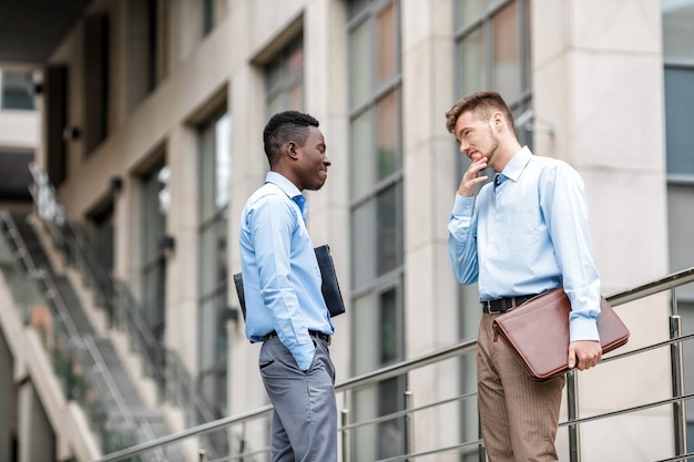 Homme d'affaires afro-américain et un homme d'affaires caucasien discutant sur la ville