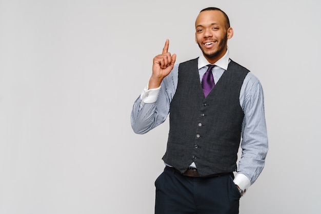 Homme d'affaires afro-américain montrant par le doigt sur gris