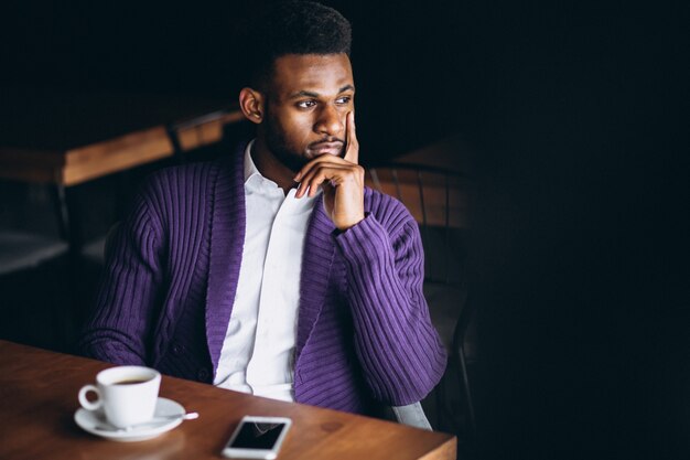 Homme d&#39;affaires afro-américain avec téléphone et café dans un café