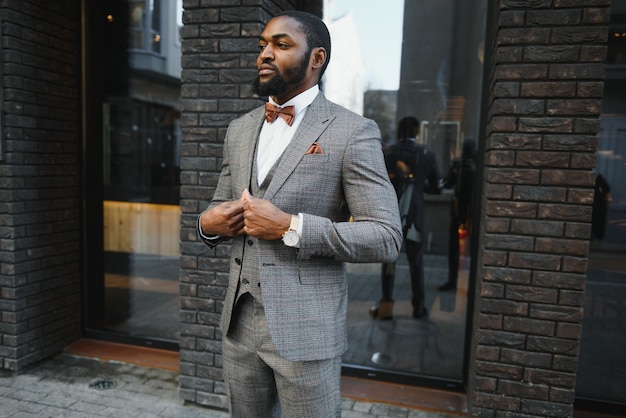Homme d'affaires afro-américain vêtu d'un costume debout dans un environnement d'affaires en plein air