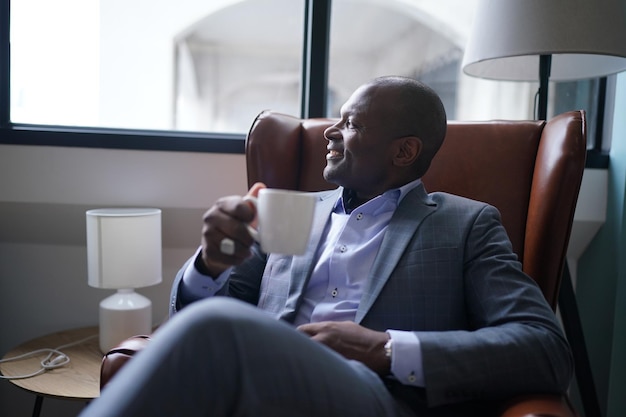 Homme d'affaires afro buvant du café