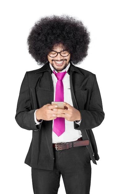 Un homme d'affaires afro utilise un téléphone portable en studio.