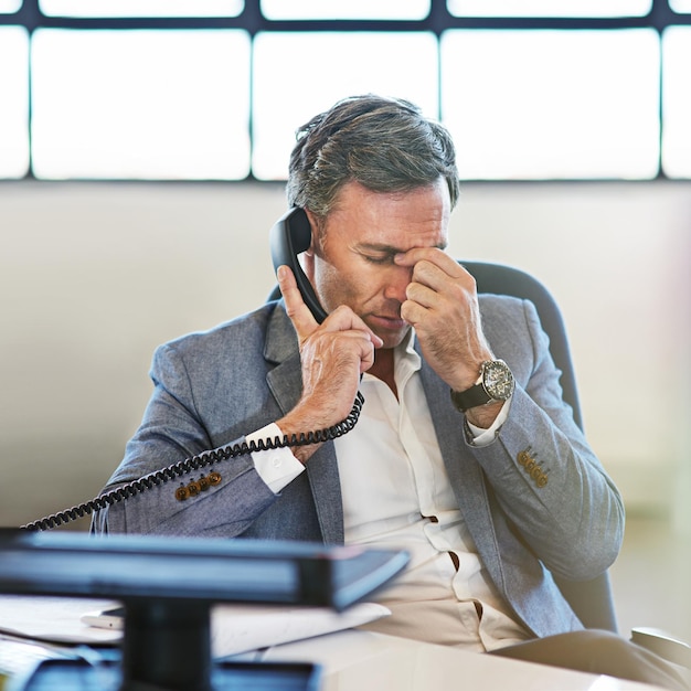 Homme d'affaires âgé mal de tête et appel téléphonique au bureau pour la communication en ligne et employé fatigué Homme frustré mal de tête et stress lié aux délais ou anxiété des employés pour un appel téléphonique d'entreprise