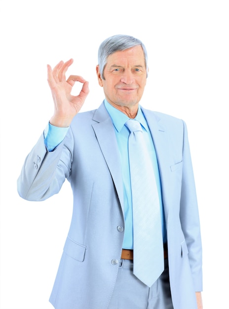 L'homme d'affaires de l'âge montre que tout va bien. Isolé sur fond blanc.