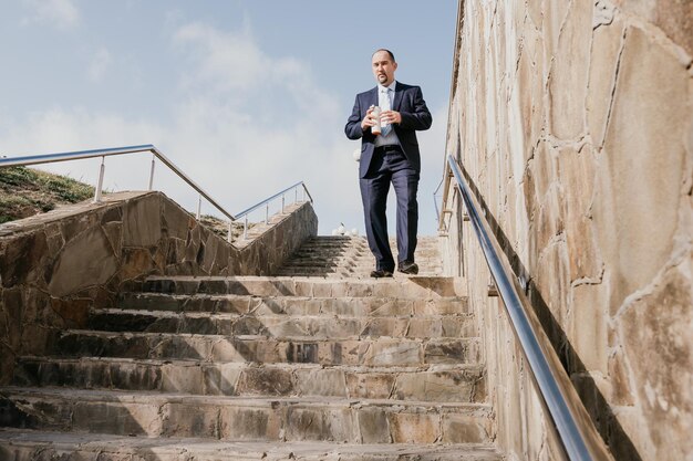 Homme d'affaires d'âge moyen confiant avec une mallette marchant à l'étage libre d'un homme d'affaires portant du bleu