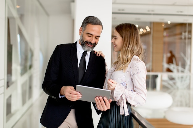 Homme d&#39;affaires d&#39;âge moyen et jeune femme d&#39;affaires avec tablette en bureau