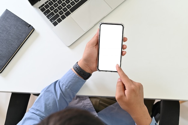 Homme d&#39;affaires à l&#39;aide de maquette smartphone sur le bureau, écran de visualisation de tracé de détourage.