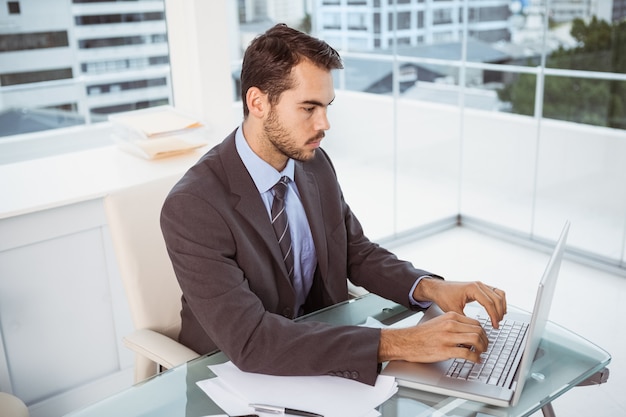 Homme d&#39;affaires à l&#39;aide d&#39;un ordinateur portable au bureau