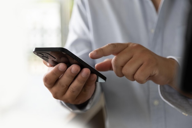 Homme d'affaires à l'aide d'un téléphone portable en tapant le chat pour contacter des idées d'affaires de communication reliant le professionnel du message publicitaire au travail