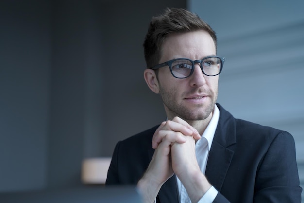 Homme d'affaires allemand élégant en costume formel et lunettes pensant à la prochaine réunion