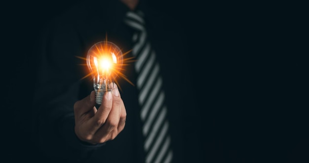 Homme d'affaires avec une ampoule pour éclairer une technologie innovante dans la science et le concept de communication Des idées et des innovations nouvelles avec une Ampoule