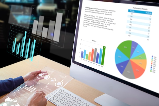 Homme d'affaires ou analyste devant un ordinateur de bureau tenant un écran de tablette transparent moderne examinant les performances de l'entreprise et un retour sur investissement, le retour sur investissement et l'analyse des risques d'investissement