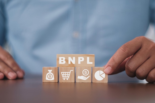 Photo homme d'affaires appuyant son doigt sur les cubes en bois avec bnpl avec des icônes d'achat en ligne. bnpl achetez maintenant payez plus tard le concept d'achat en ligne.